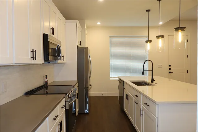a kitchen with sink a refrigerator and microwave