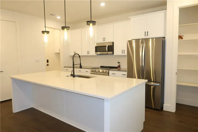 a kitchen with stainless steel appliances a sink and a refrigerator