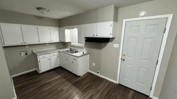 a kitchen with sink cabinets and wooden floor