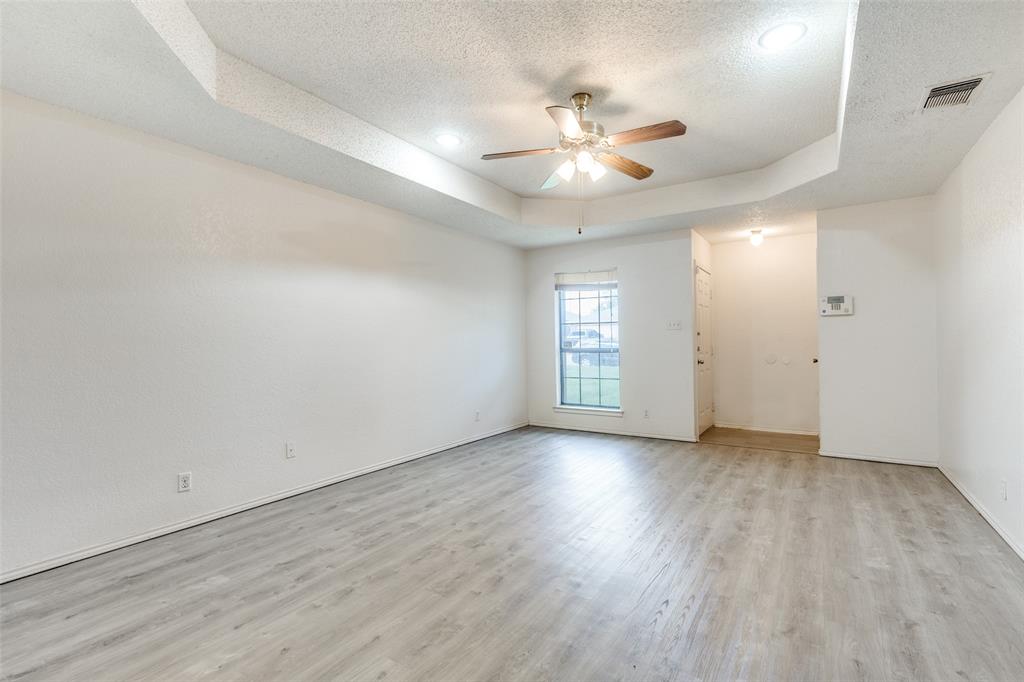 1913 San Rafael Street Fort Worth, TX 76134 - Photo 3 of 12 an empty room with wooden floor chandelier fan and windows