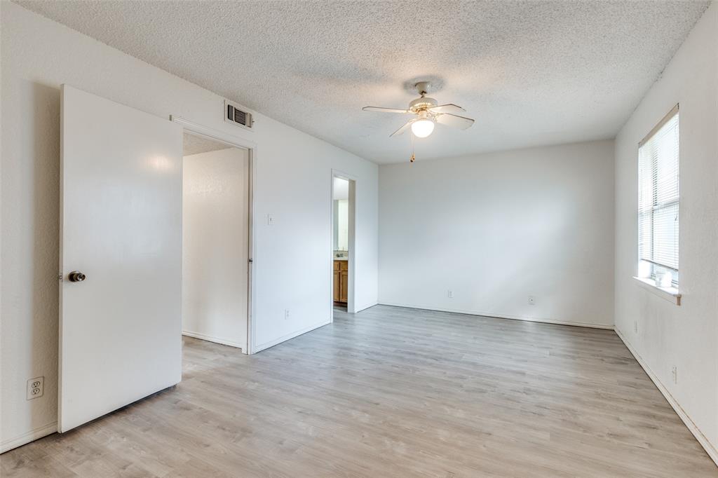1913 San Rafael Street Fort Worth, TX 76134 - Photo 4 of 12 a view of an empty room with wooden floor and a window