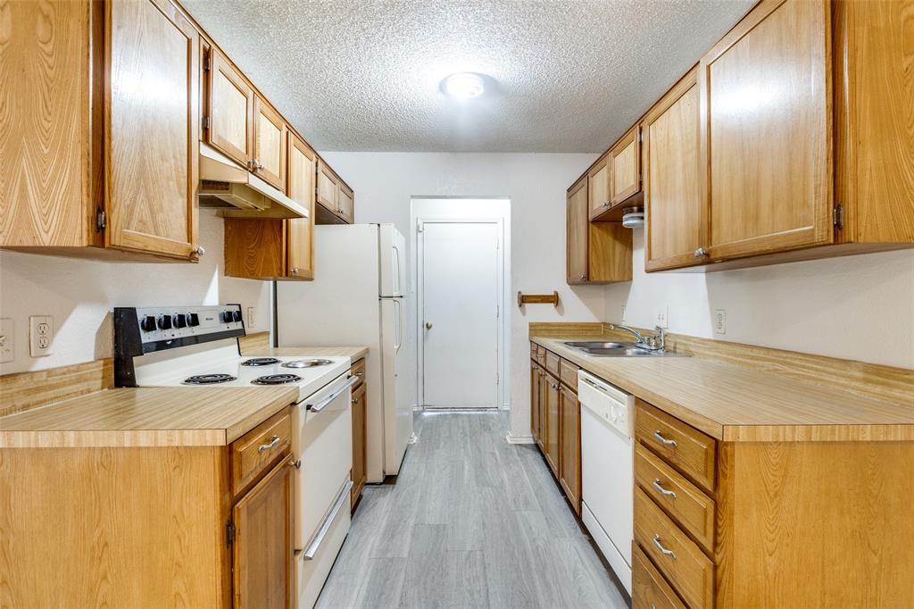 1913 San Rafael Street Fort Worth, TX 76134 - Photo 6 of 12 a kitchen with stainless steel appliances granite countertop a stove a sink dishwasher and a refrigerator