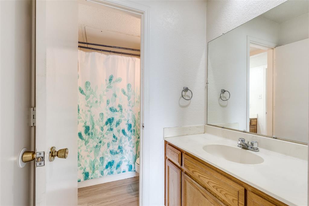 1913 San Rafael Street Fort Worth, TX 76134 - Photo 10 of 12 a bathroom with a granite countertop sink and a mirror