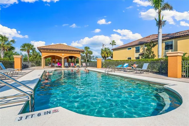 a view of a swimming pool with lawn chairs under an umbrella