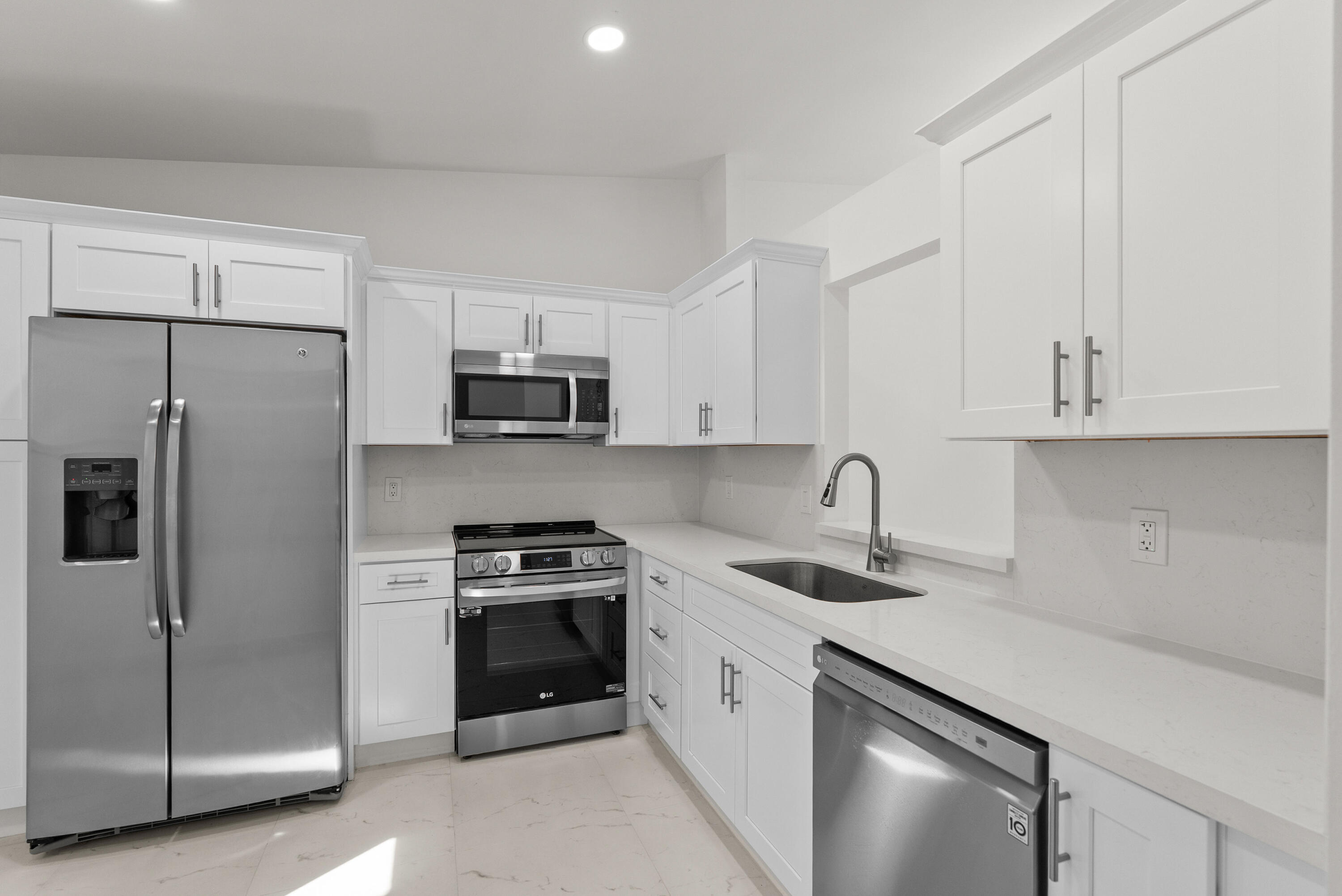 8273 Springtree Road Boca Raton, FL 33496 - Photo 14 of 36 a kitchen with white cabinets and stainless steel appliances