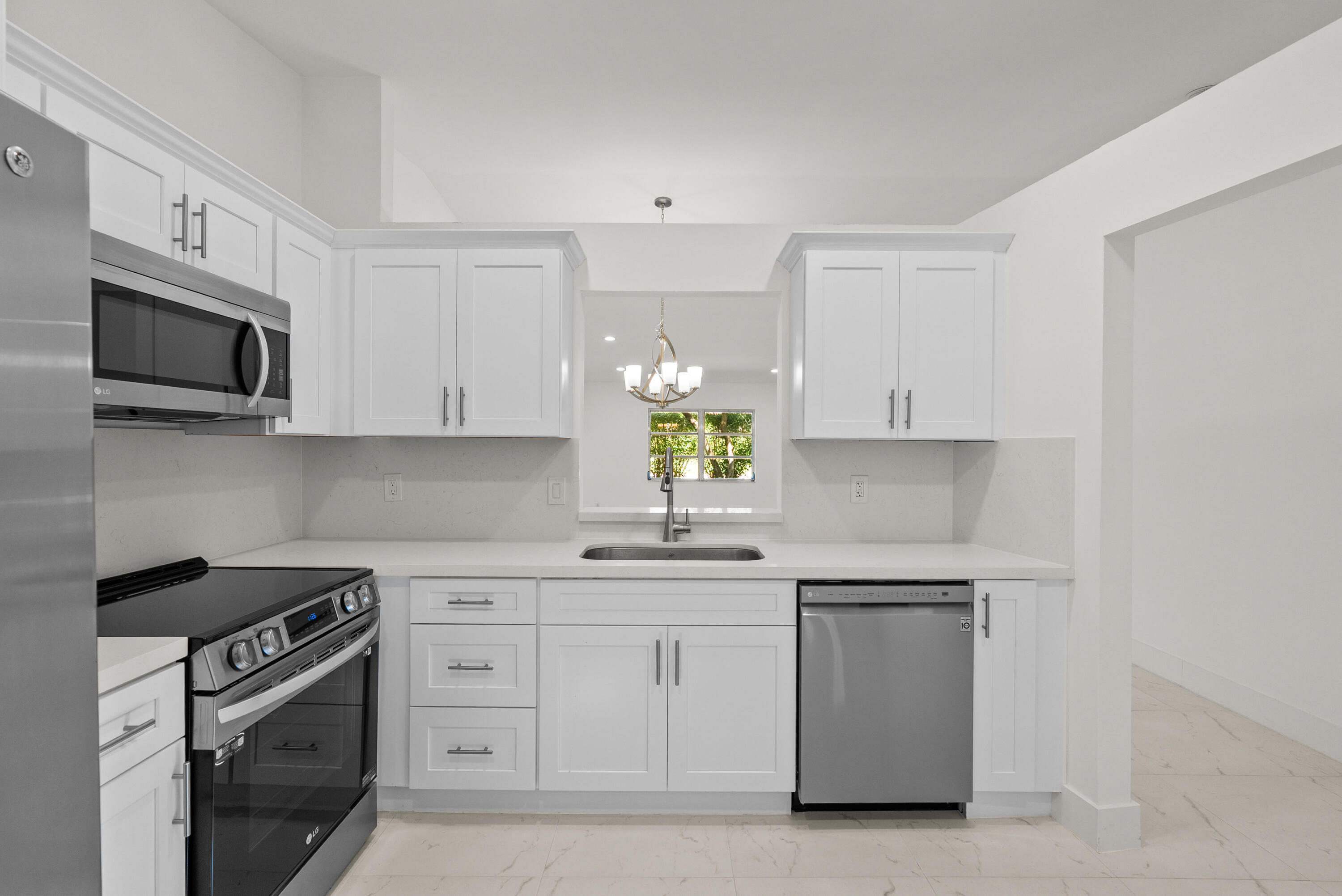 8273 Springtree Road Boca Raton, FL 33496 - Photo 16 of 36 a kitchen with white cabinets stainless steel appliances and sink