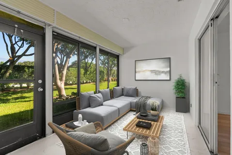a living room with furniture and a floor to ceiling window