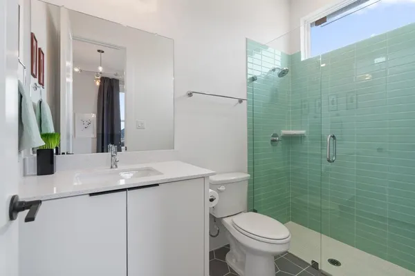 a bathroom with a granite countertop toilet sink and mirror