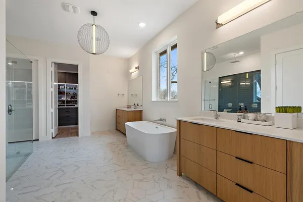 a spacious bathroom with a double vanity sink a mirror and a bathtub