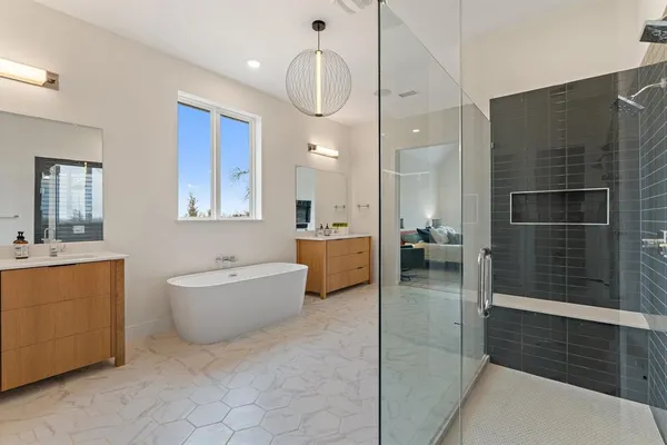a bathroom with a tub a sink and mirror