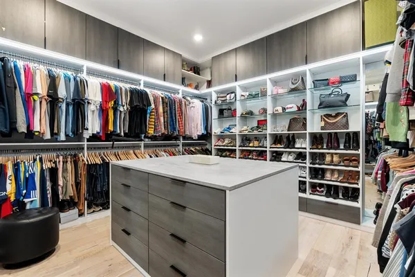 a view of walk in closet with clothes and shoes
