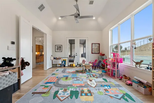 a bed room with a bed a dresser and a chandelier