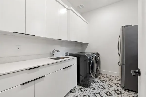 a utility room with sink dryer and washer