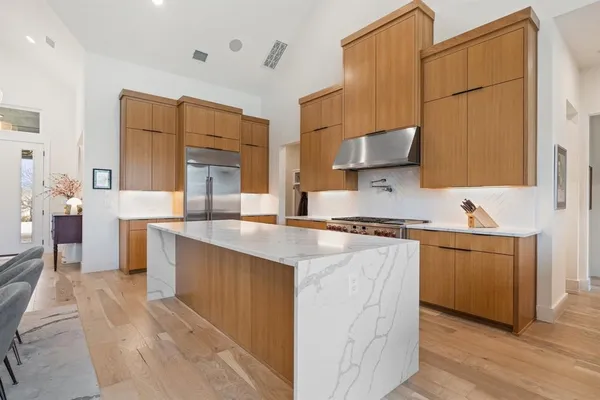 a kitchen with stainless steel appliances granite countertop a sink stove and refrigerator