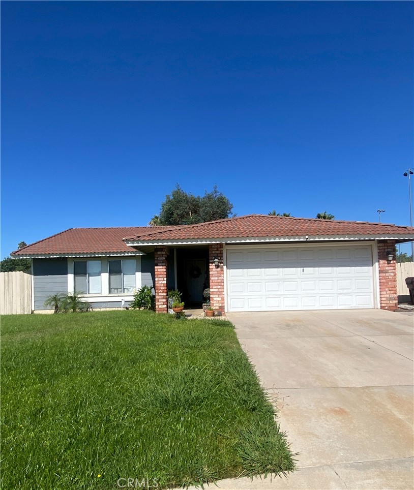 a view of a house with a yard and a garage