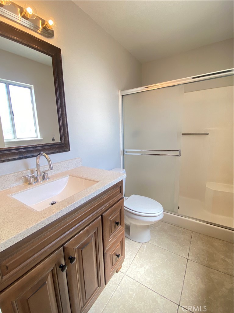 14663 Rio Grande Drive Moreno Valley, CA 92553 - Photo 13 of 15 a bathroom with a granite countertop sink toilet and shower
