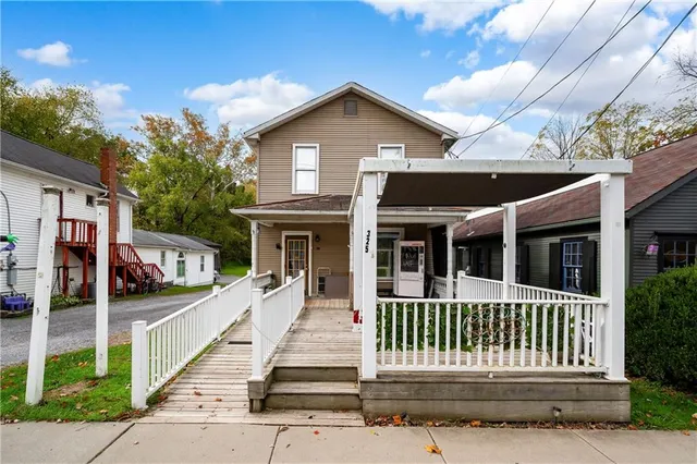 a front view of a house with a garden