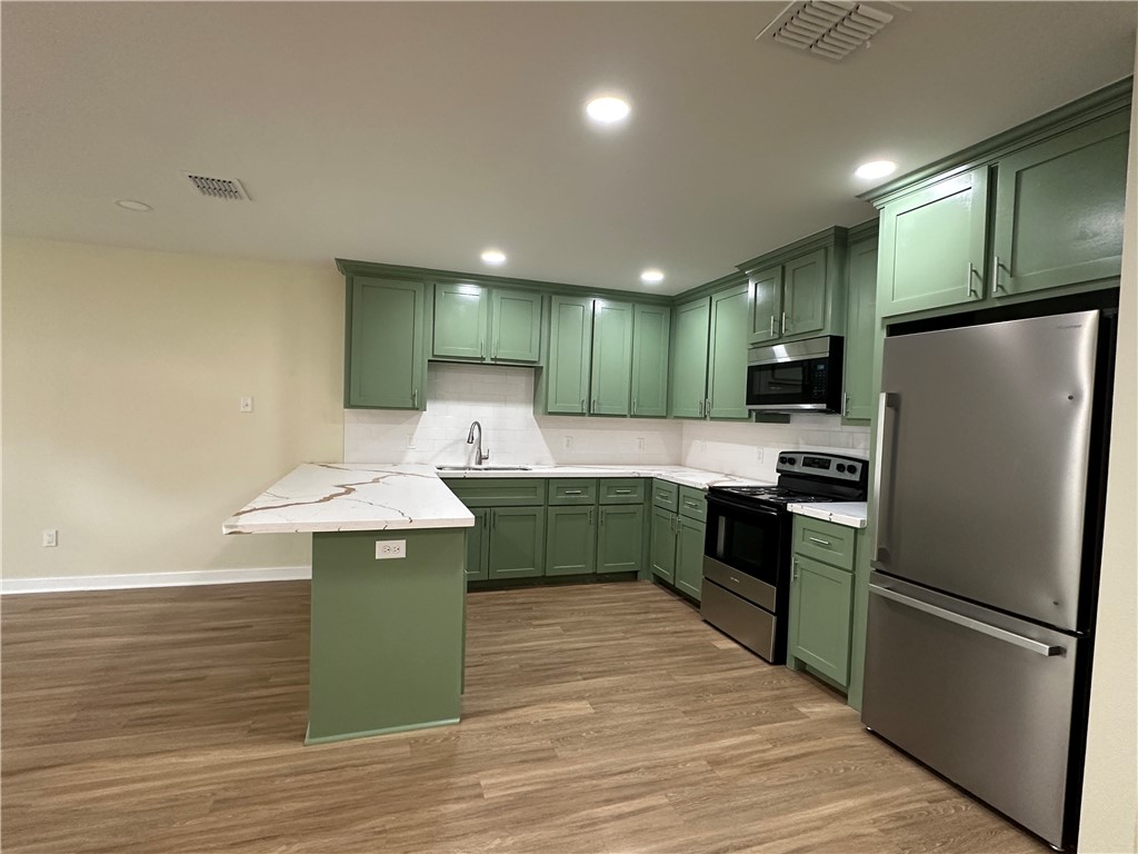 923 Craig Street, Unit B Corpus Christi, TX 78404 - Photo 3 of 9 a kitchen with a refrigerator sink and cabinets