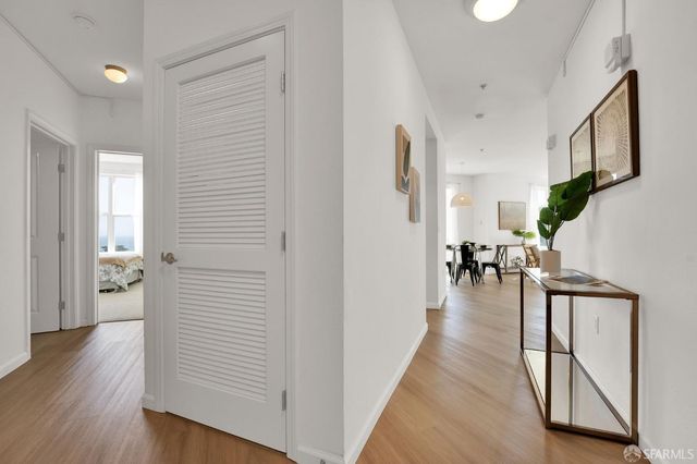 a view of a hallway with wooden floor and a living room