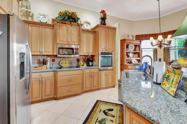 a kitchen with stainless steel appliances granite countertop a refrigerator a stove top oven a sink and dishwasher
