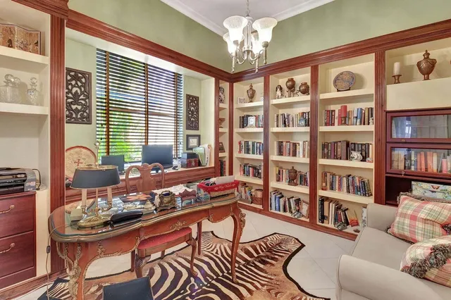 a living room with furniture a bookshelf and a window