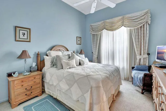a bedroom with bed and a large mirror on the dresser