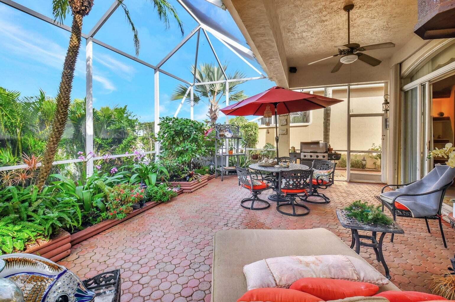 7035 Vivaldi Lane Delray Beach, FL 33446 - Photo 21 of 39 a view of a patio with table and chairs under an umbrella