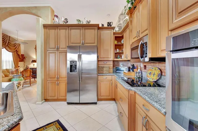 a kitchen with stainless steel appliances granite countertop a refrigerator and a stove