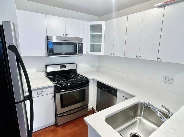 a kitchen with stainless steel appliances granite countertop a sink stove and refrigerator
