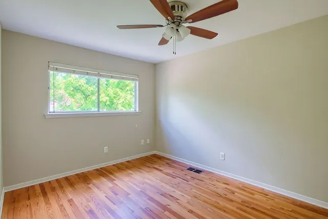 an empty room with a window and wooden floor