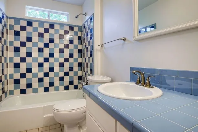 a bathroom with a sink a toilet and shower curtain