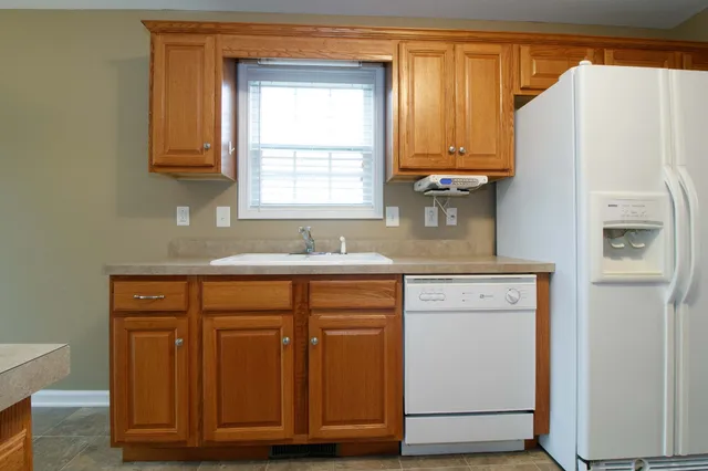 a kitchen with stainless steel appliances granite countertop a refrigerator and cabinets