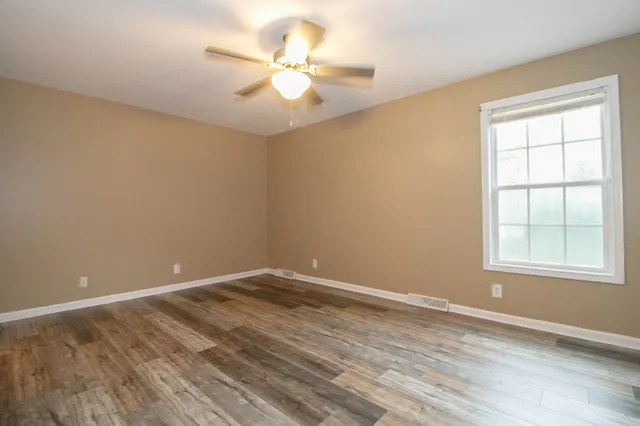wooden floor in an empty room with a window