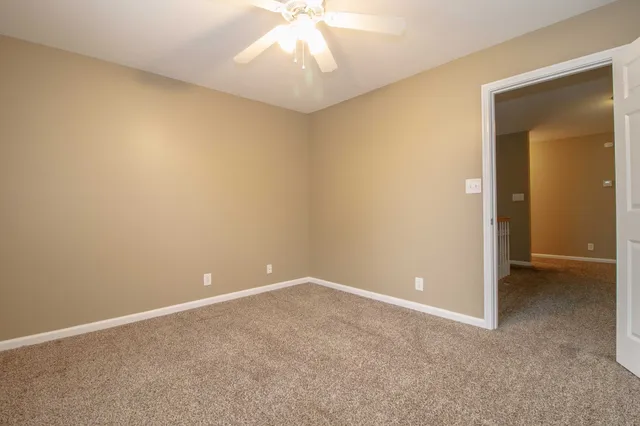 an empty room and a chandelier fan