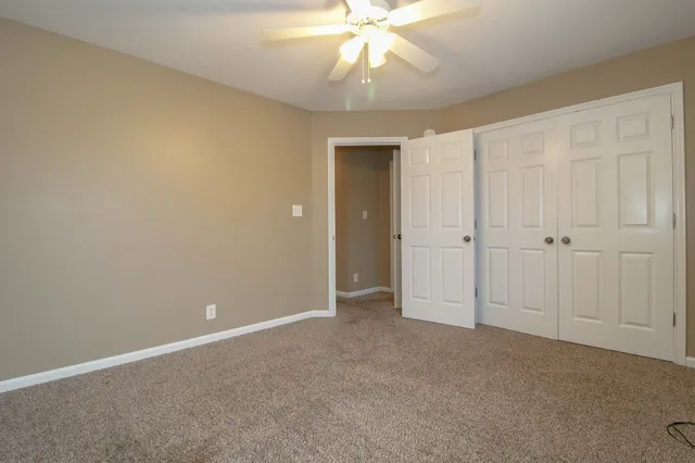 an empty room with a ceiling fan and a window