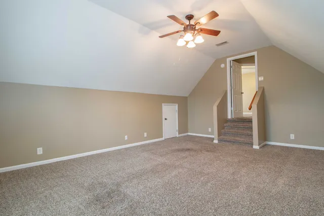 a view of an empty room with a chandelier fan