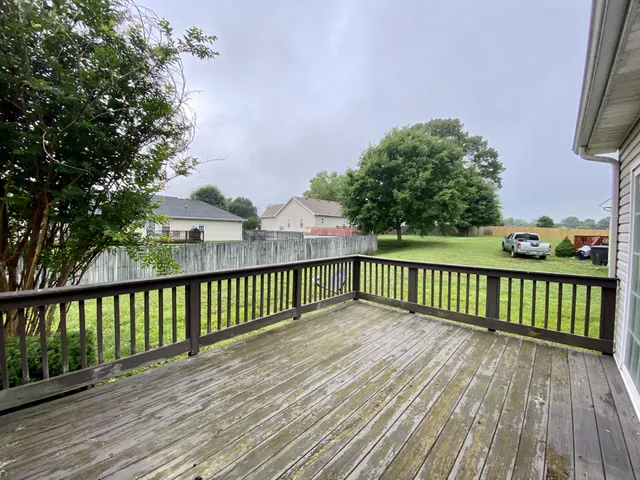 a view of balcony with wooden floor and fence