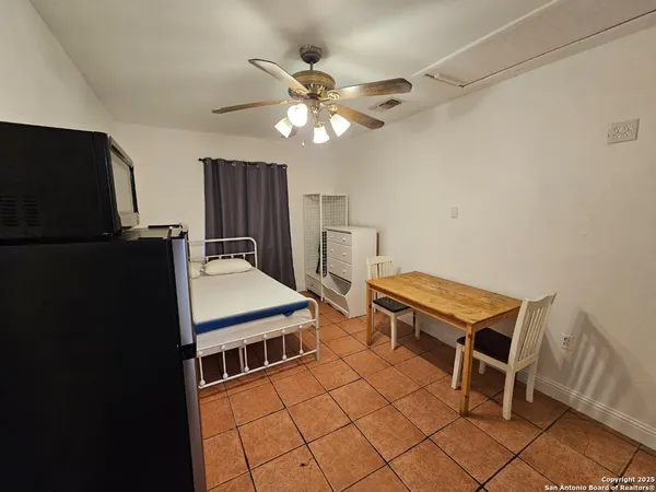 a room with furniture and a chandelier fan