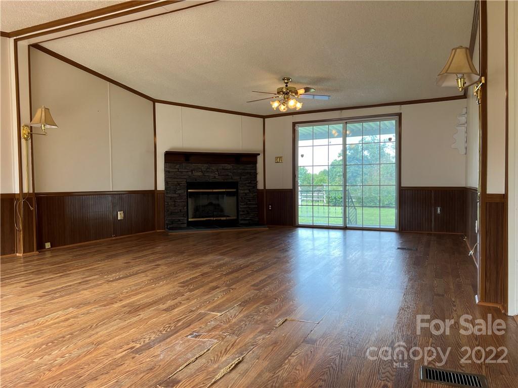 8581 Highway 268 Elkin, NC 28621 - Photo 8 of 45 an empty room with windows fireplace and chandelier