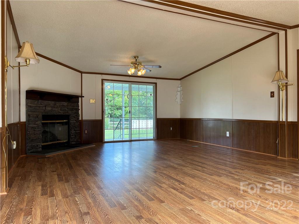 8581 Highway 268 Elkin, NC 28621 - Photo 10 of 45 a view of an empty room with wooden floor fireplace and a window
