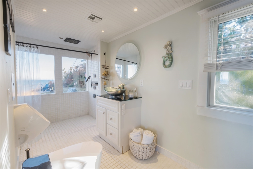 232 Manomet Point Road Plymouth, MA 02360 - Photo 7 of 24 a bathroom with a sink a toilet and a large mirror