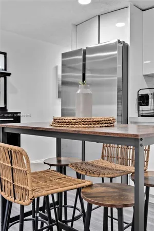 a kitchen with a table chairs and a refrigerator