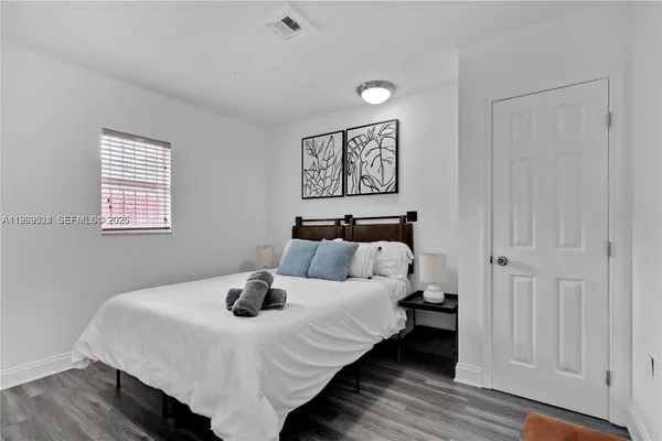 a bedroom with a bed and wooden floor