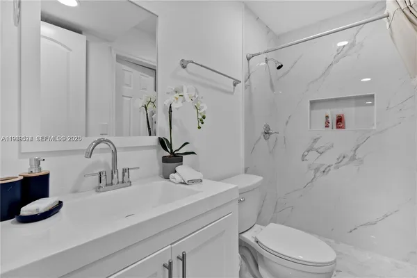 a bathroom with a sink a toilet and shower