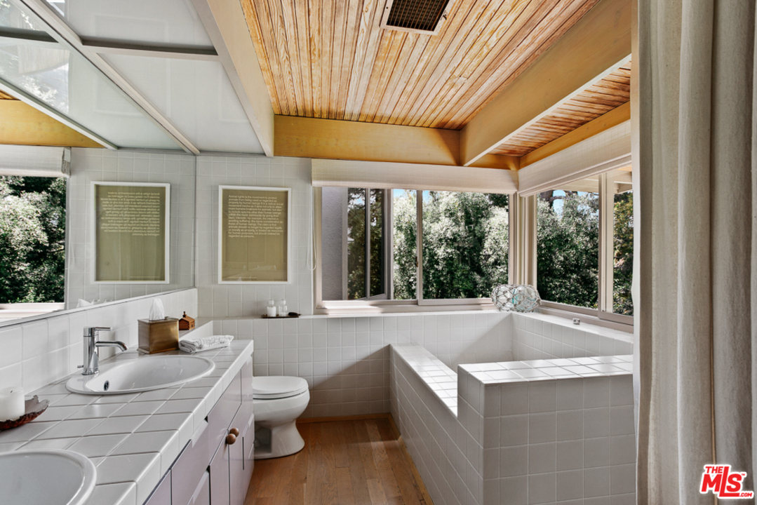 11600 Amanda Drive Studio City, CA 91604 - Photo 11 of 33 a bathroom with a granite countertop sink and mirror with bathtub