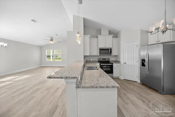 a kitchen with granite countertop a refrigerator and a sink