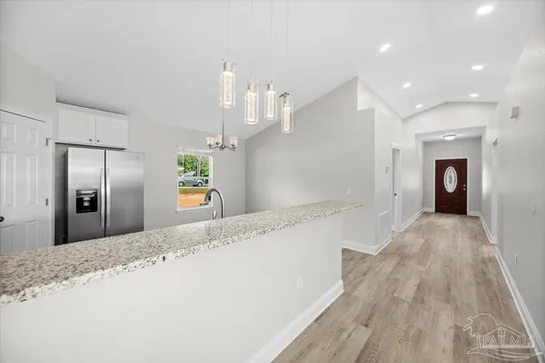 a view of a kitchen with a sink and wooden floor