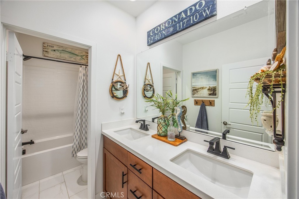 5806 Dragonfly Street Banning, CA 92220 - Photo 6 of 40 a bathroom with double vanity sink and a mirror