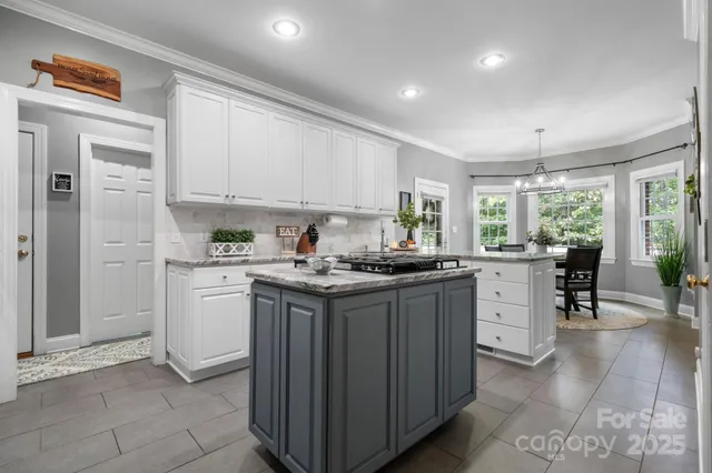 a kitchen with granite countertop cabinets stainless steel appliances a sink and a window
