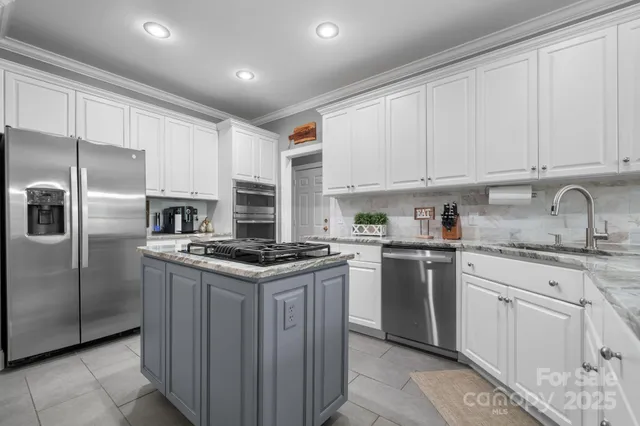 a kitchen with granite countertop a sink stove and refrigerator